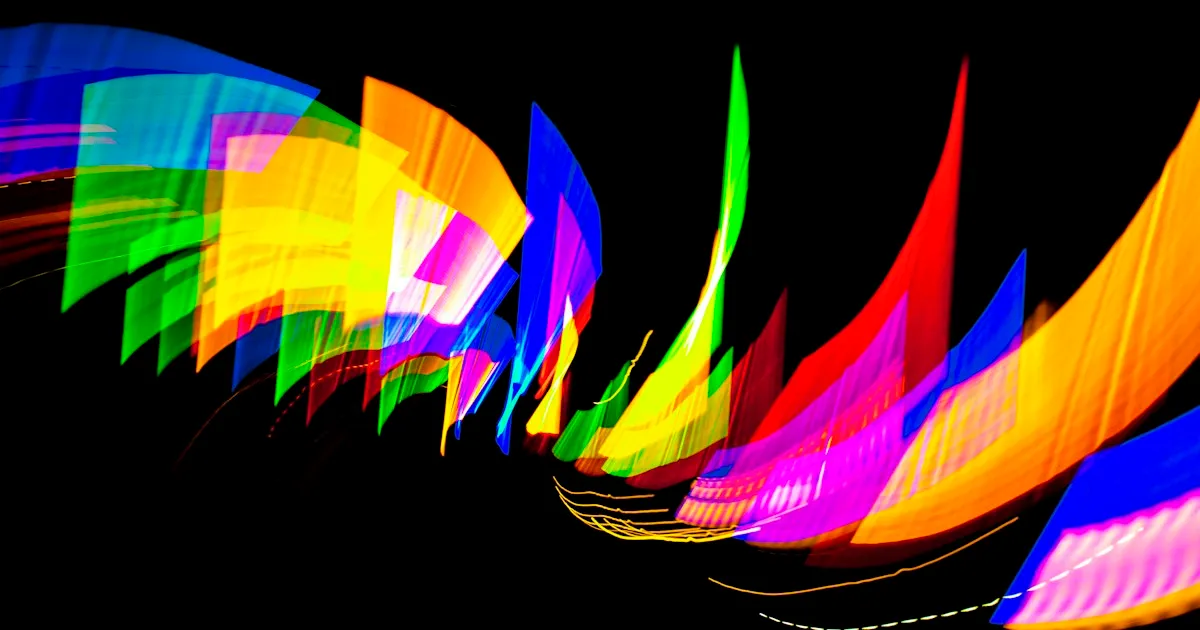 Traînées de lumière colorées en formes courbes sur fond noir