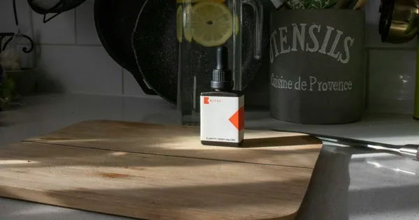Bouteille d'huile d'olive verte posée sur un plan de travail, étiquette tournée vers l'objectif