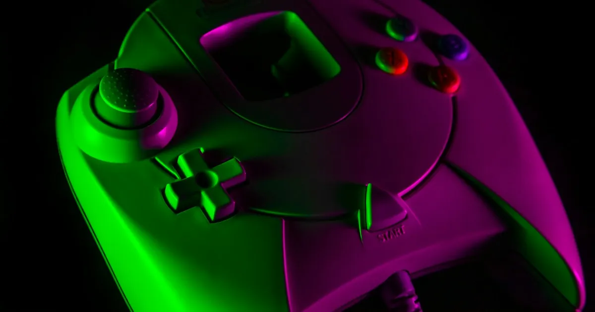 Manette de jeu vidéo verte et violette éclairée au néon sur fond noir