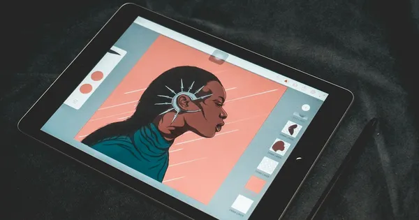 Tablette posée sur un tissu sombre, affichant le portrait dessiné d'une femme et son panneau de calques