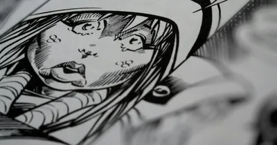 Planche de manga en cours d'encrage sur une table de travail encombrée