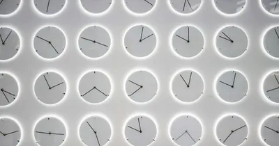 Grille de cadrans d'horloge blancs dans des disques clairs, aiguilles placées différemment