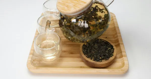 Feuilles de thé en cours d'infusion dans une théière en verre transparent